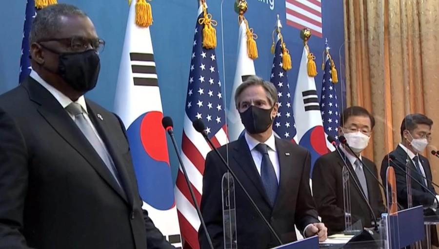 A group of people standing in front of flags

Description automatically generated with low confidence