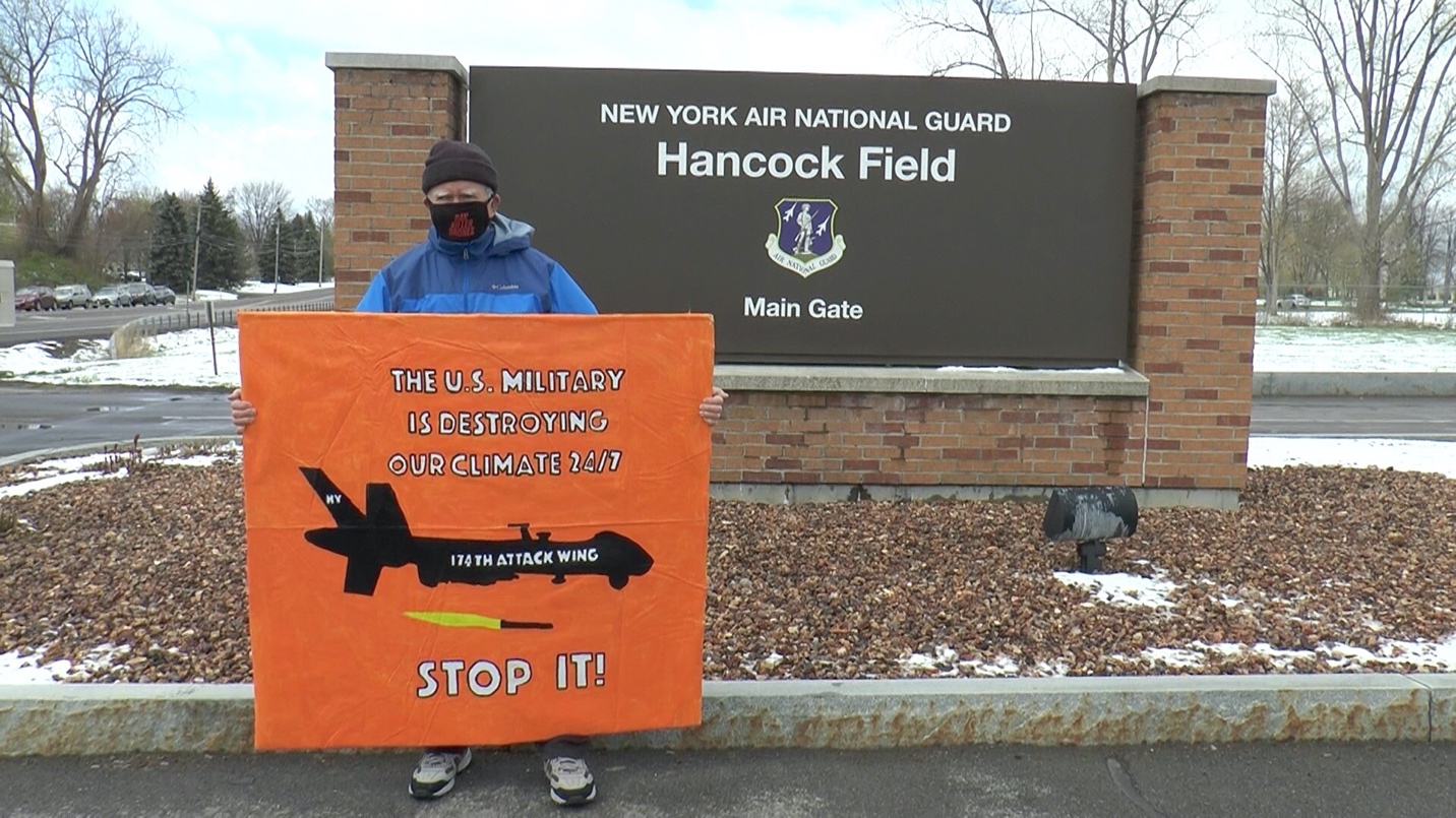 A person standing behind a sign
Description automatically generated with low confidence