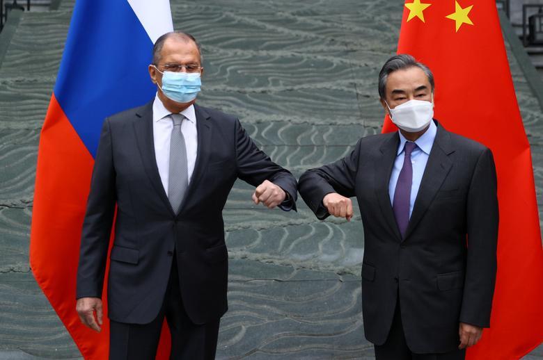 Russia's Foreign Minister Sergei Lavrov and China's State Councilor and Foreign Minister Wang Yi wearing protective face masks pose for a picture during a meeting in Guilin, China March 22, 2021. Russian Foreign Ministry/Handout via REUTERS