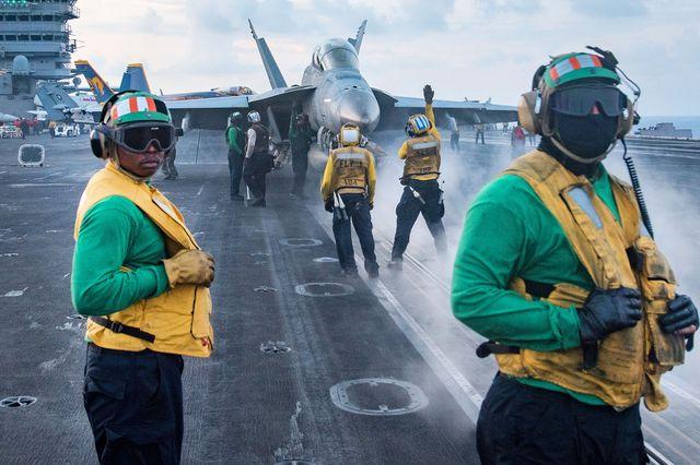 U.S. sailors conduct flight operations on the deck of the aircraft carrier USS Carl Vinson. American Navy aircraft carrier strike groups regularly patrol regional waters, fueling tensions in the South China Sea.