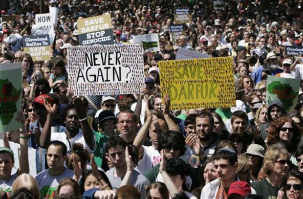 A crowd of people holding signs
Description automatically generated