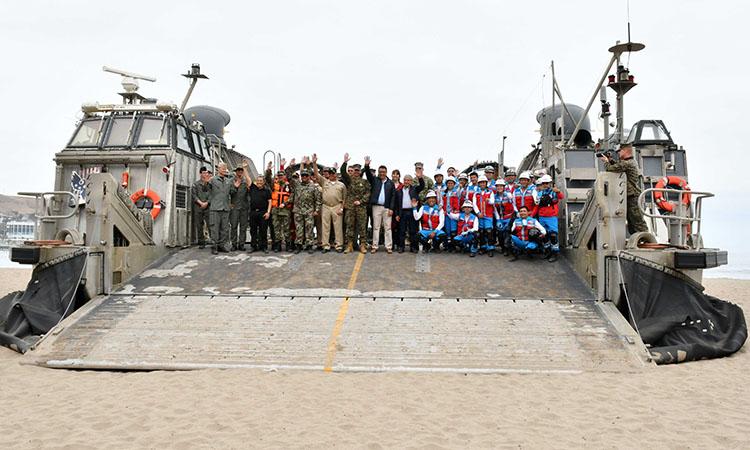 A group of people posing for a photo next to a large ship

Description automatically generated with low confidence