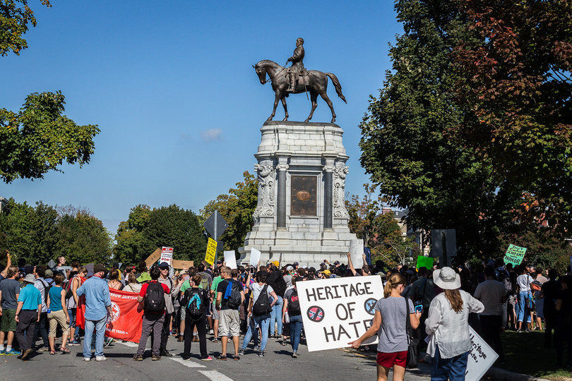A group of people standing around a statue of a person on a horse

Description automatically generated with medium confidence