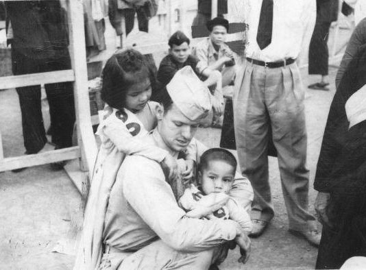 The Cautionary Tale Of “Doctor America”: How Dr. Tom Dooley—Once A Universally Revered Secular Saint to Millions—Found the CIA and Lost His Halo A picture containing person, posing, playground, crowd Description automatically generated