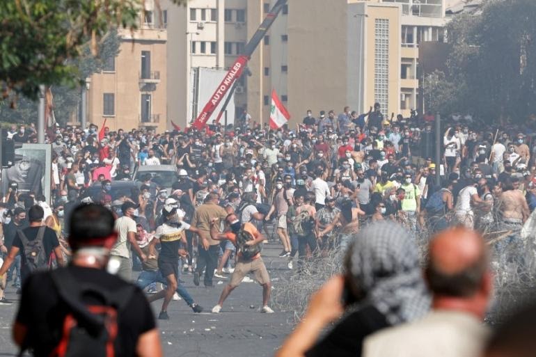 Demonstrators throw stones during a protest on August 8 as they try to break through a barrier to the parliament building following Tuesday's blast in Beirut, Lebanon [REUTERS/Thaier Al-Sudani [Daylife]