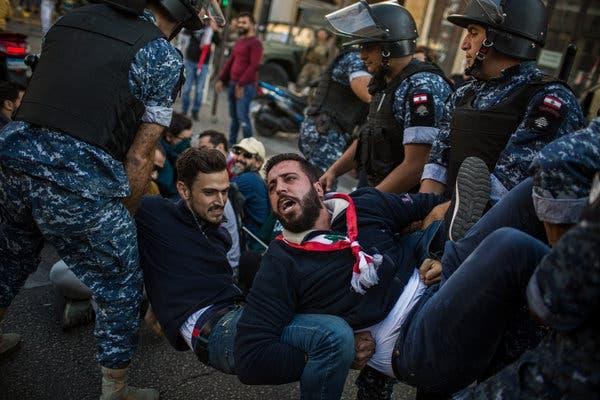 Riot police officers removing antigovernment protesters from an intersection in Beirut.