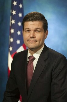 A person in a suit and tie
Description automatically generated with medium confidence