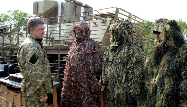 In this photo taken on Friday, June 20, 2014 in Izyum close to Slovyansk, eastern Ukraine Ukrainian President Petro Poroshenko, left, visits troops. Poroshenko in a televised address early Tuesday, July 1, 2014, said he was abandoning a unilateral cease-fire in the conflict with pro-Russian separatists and sending military forces back on the offensive after talks with Russia and European leaders failed to start a broader peace process. The cease-fire expired Monday evening.