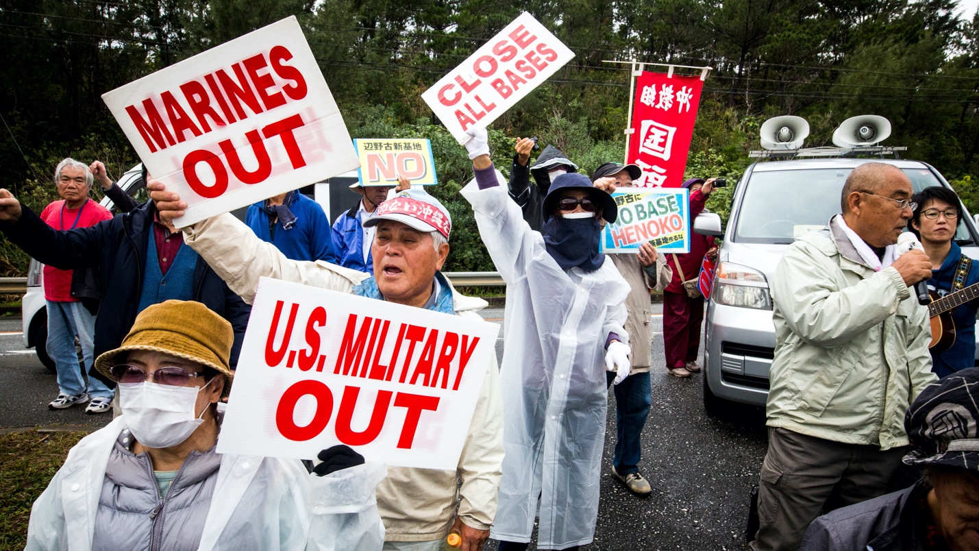 Residents holding placards reading US Military out protect the relocation of the new U.S Marine Airbase construction on...