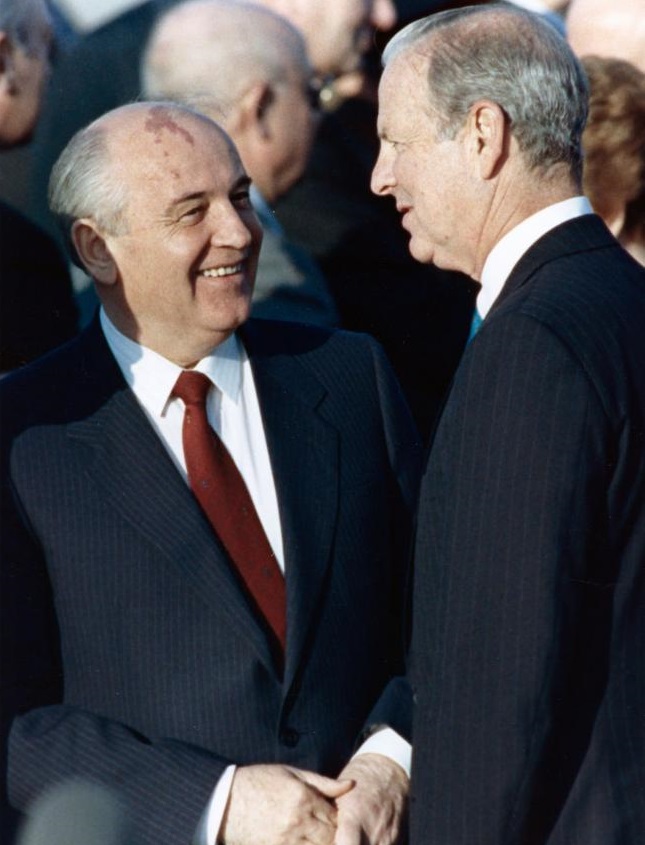 A person in a suit talking to another person

Description automatically generated with low confidence