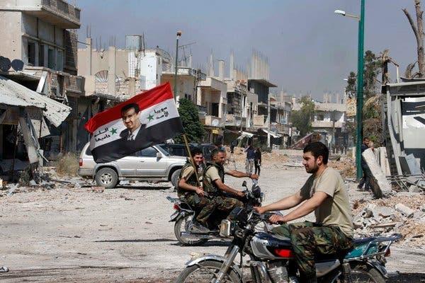 Forces loyal to President Bashar al-Assad carried a flag on Wednesday after taking the town of Qusayr.