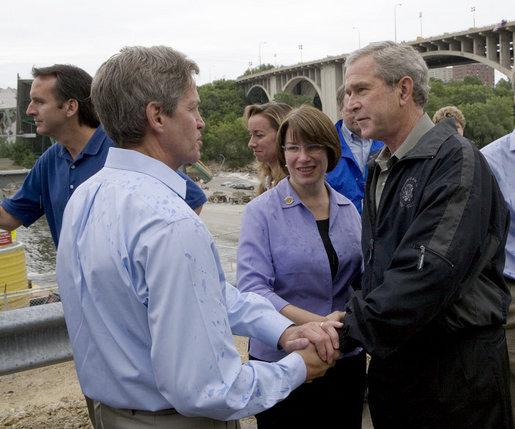 President George W. Bush shakes hands with Minnesota Senator Norm Coleman, left, and greets Senator Amy Klobuchar, (center), , at the conclusion of the President's visit Saturday, Aug. 4, 2007, to the site of the I-35W bridge collapse in Minneapolis. White House photo by Chris Greenberg