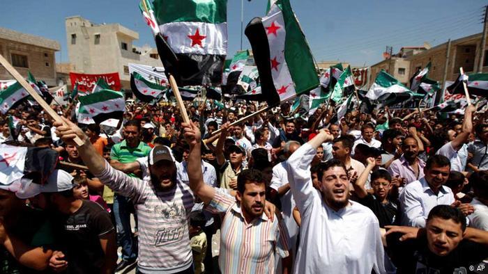 Syrians attend an anti-Bashar Assad protest after Friday prayers on the outskirts of Idlib, Syria, Friday, June 8, 2012.