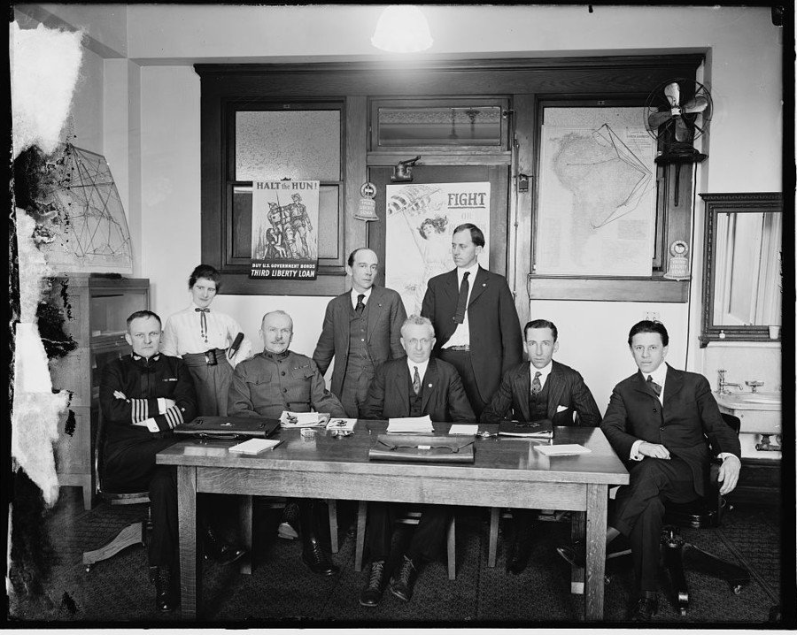 A group of men sitting around a table
Description automatically generated with medium confidence