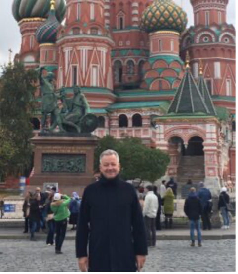 A person standing in front of a building with a statue on top

Description automatically generated with medium confidence