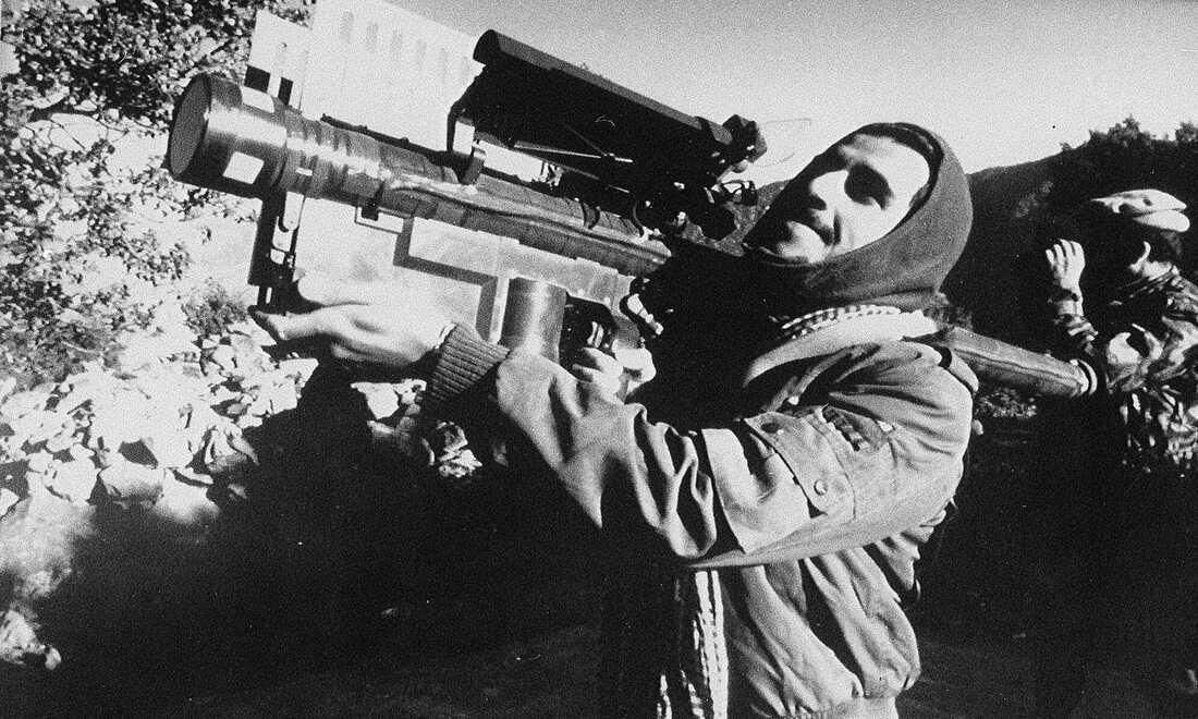 A picture containing text, outdoor, person, weapon
Description automatically generated