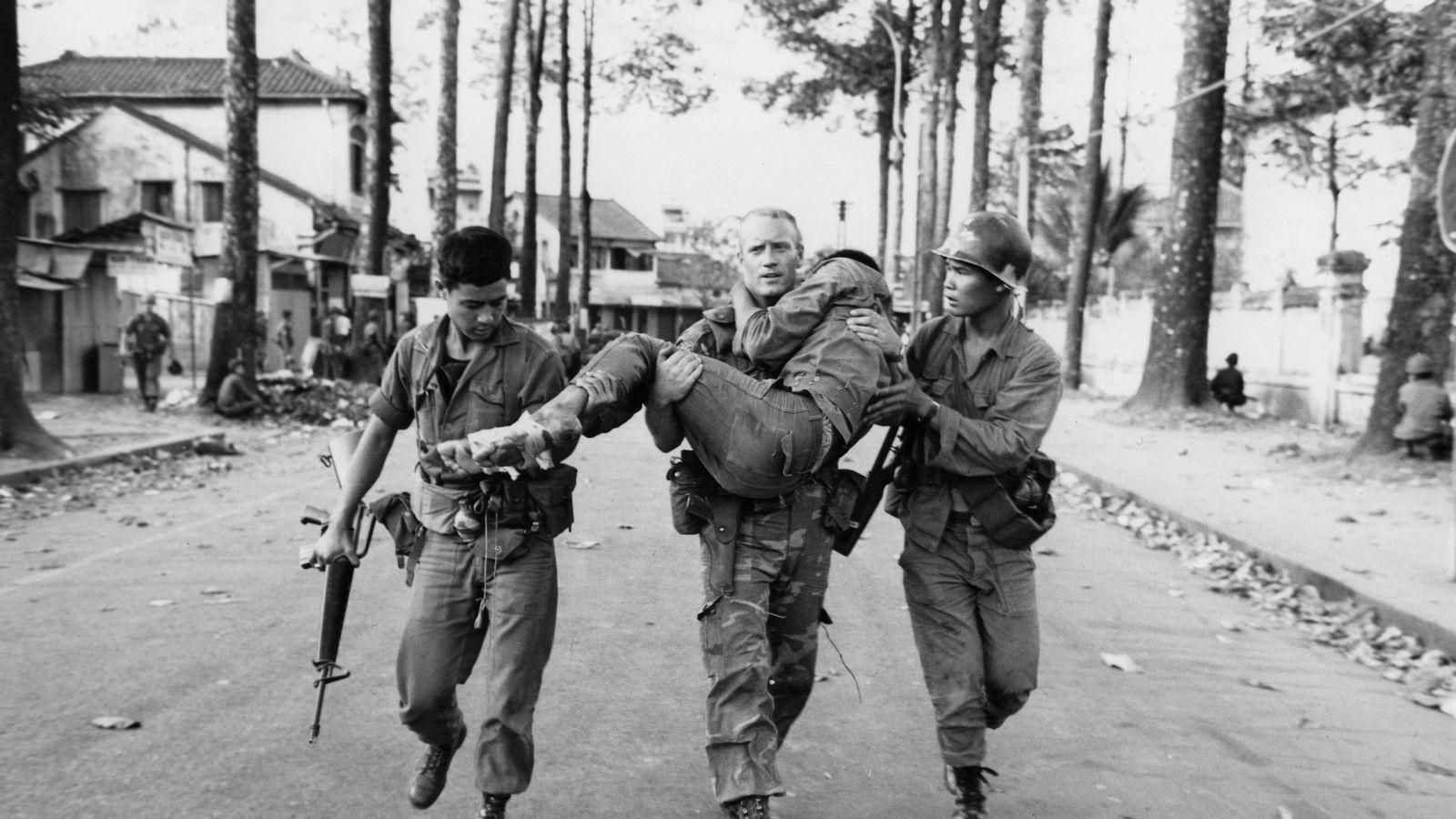 In his Feb. 6, 1968, file photo, First Lt. Gary D. Jackson of Dayton, Ohio, carries a wounded South Vietnamese Ranger to an ambulance after a brief but intense battle with the Viet Cong during the Tet Offensive near the National Sports Stadium in the Cholon section of Saigon. (AP Photo/Dang Van Phuoc, File)