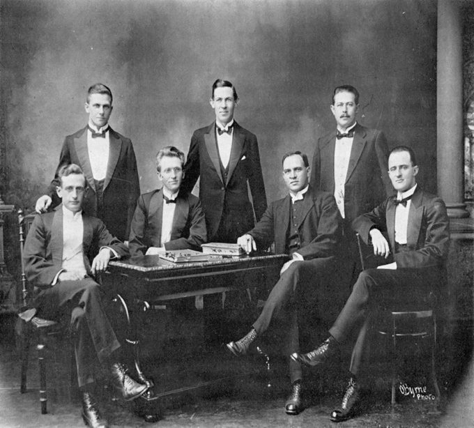 A group of men sitting around a table

Description automatically generated
