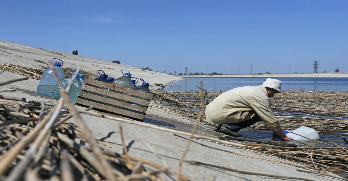 A man scoops water into containers on the bank of a section of the North Crimean Canal outside the town of Krasnoperekopsk, in northern Crimea, May 10, 2014. (Reuters File Photo)