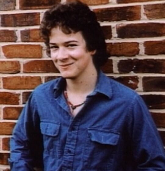 A person smiling in front of a brick wall
Description automatically generated with medium confidence