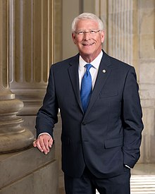 A person in a suit and tie

Description automatically generated with low confidence