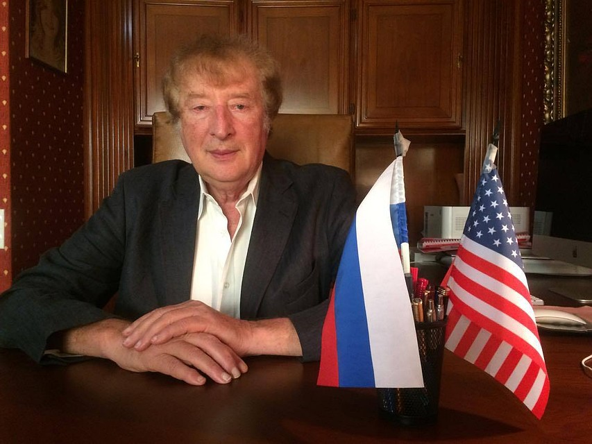 A person sitting at a table with flags

Description automatically generated with medium confidence