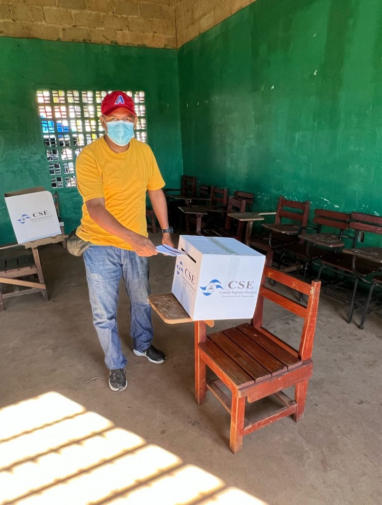 A person wearing a mask and holding a box Description automatically generated with low confidence