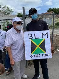 A couple of men holding a sign
Description automatically generated with low confidence