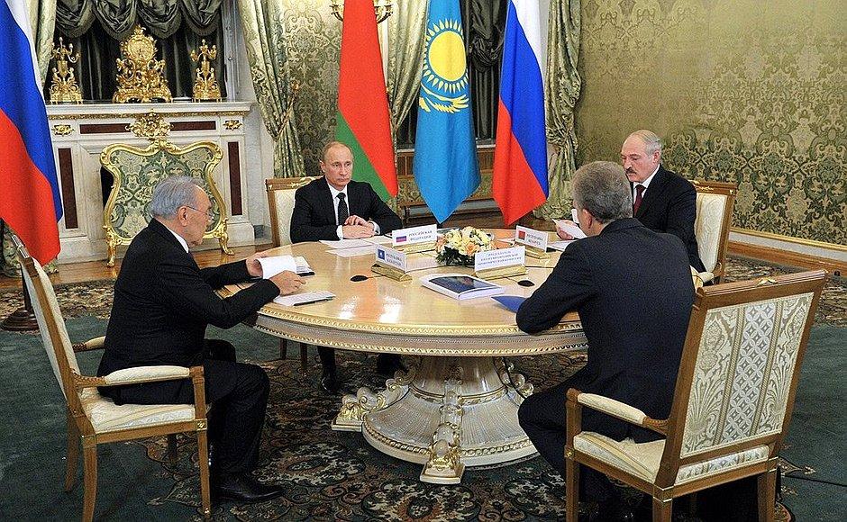 A group of men sitting around a table with flags behind them
Description automatically generated with medium confidence
