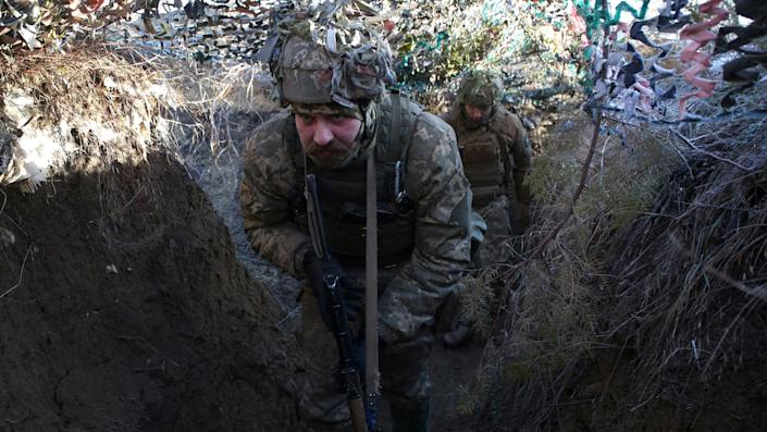 Ukrainian Military Forces servicemen walk on a trench on the frontline with Russia-backed separatists near to Avdiivka, Donetsk, southeastern Ukraine.