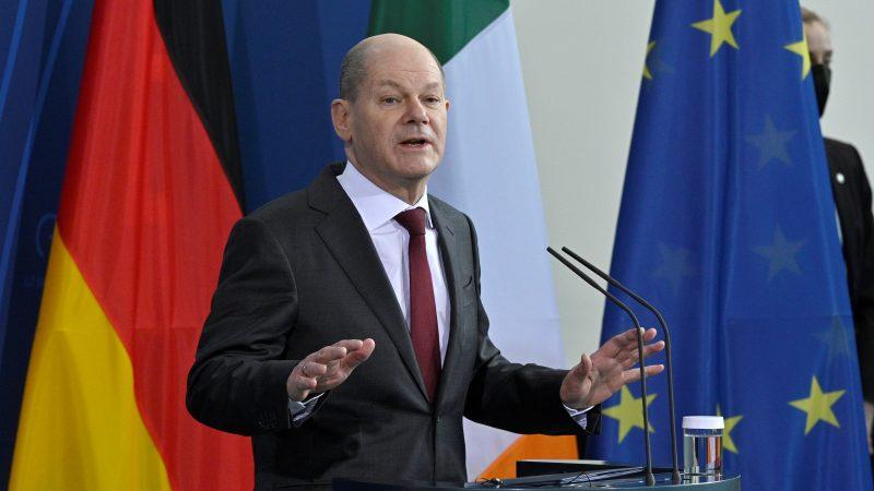 A person in a suit speaking into a microphone
Description automatically generated with low confidence