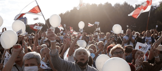A crowd of people holding flags

Description automatically generated with medium confidence