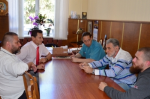 A group of men sitting around a table
Description automatically generated