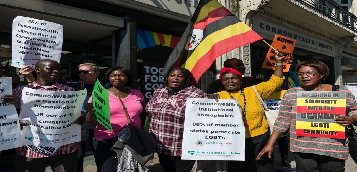 A group of people holding signs and flags

Description automatically generated