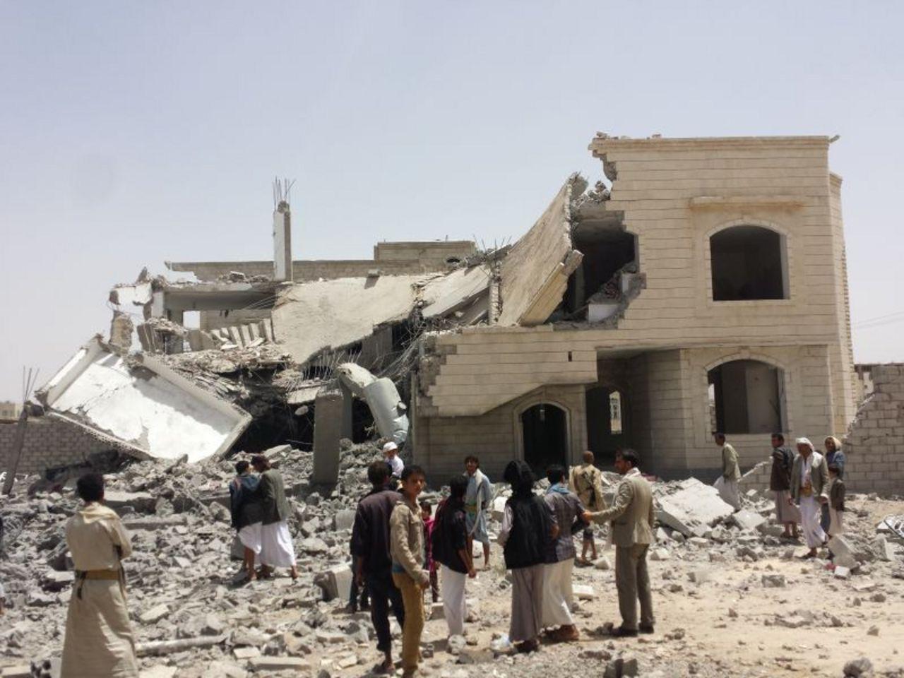 A group of people standing outside a building that is falling apart

Description automatically generated with medium confidence