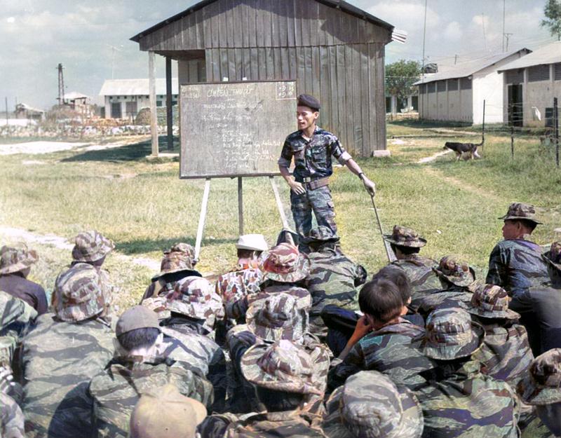 A person standing in front of a group of people sitting on the ground
Description automatically generated with medium confidence
