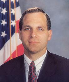 A person in a suit and tie

Description automatically generated with medium confidence
