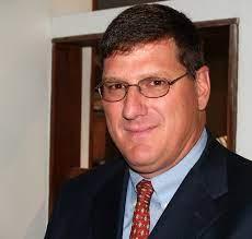 A person wearing glasses and a suit

Description automatically generated with medium confidence