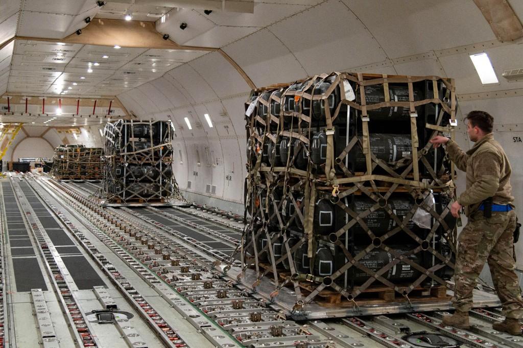 Senior Airman Cameron Manson inspects cargo netting on palletised ammunition, weapons and other equipment bound for Ukraine during a foreign military sales mission at Dover Air Force Base, Delaware,