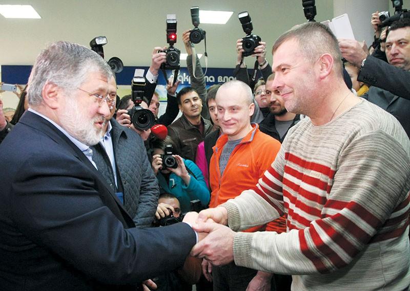 Newly appointed Dnipropetrovsk Oblast governor Ihor Kolomoisky (L) meets Yuriy Bereza, then head of regional pro-Ukrainian self-defence unit in Dnipro (then Dnipropetrovsk) on March 4, 2014. Bereza symbolically granted Kolomoisky the keys to the regional administration. One month later Bereza headed the Kolomoisky-sponsored Dnipro-1 volunteer battalion. 