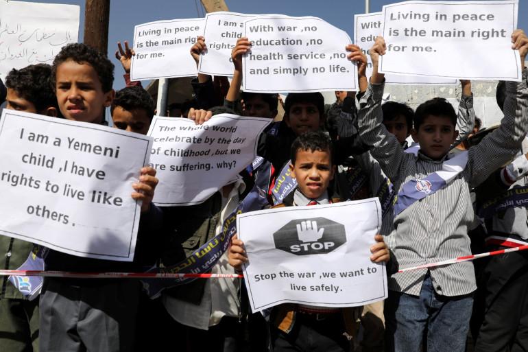 A group of people holding signs
Description automatically generated