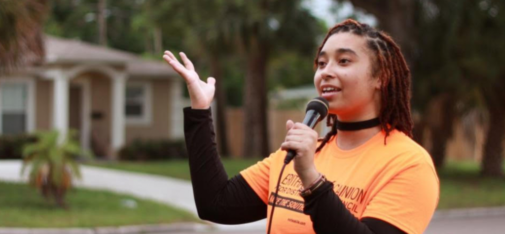 A person holding a microphone

Description automatically generated with medium confidence