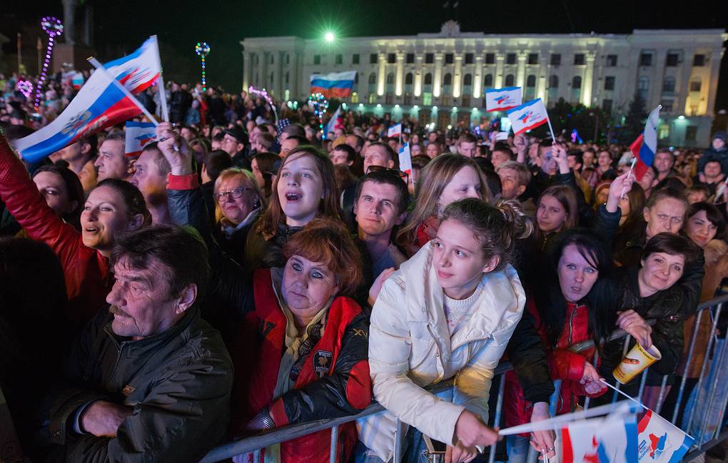 A crowd of people holding flags
Description automatically generated with medium confidence