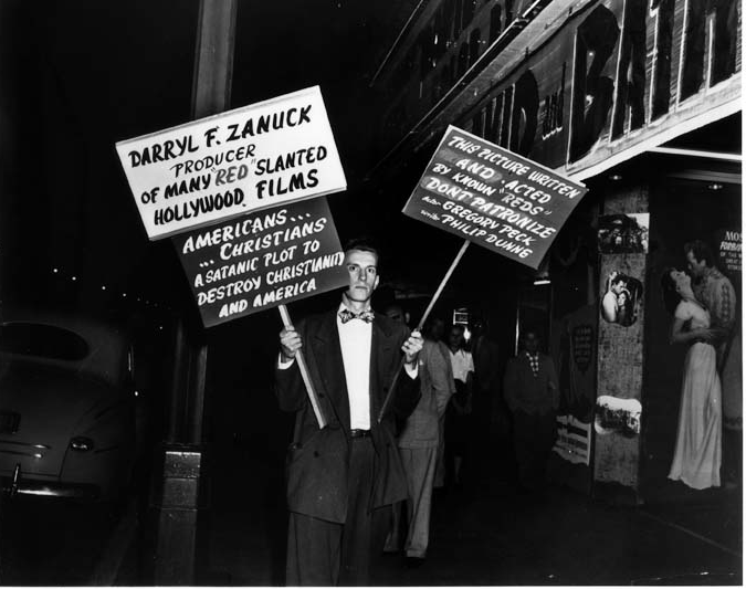 A couple of men holding signs
Description automatically generated with medium confidence