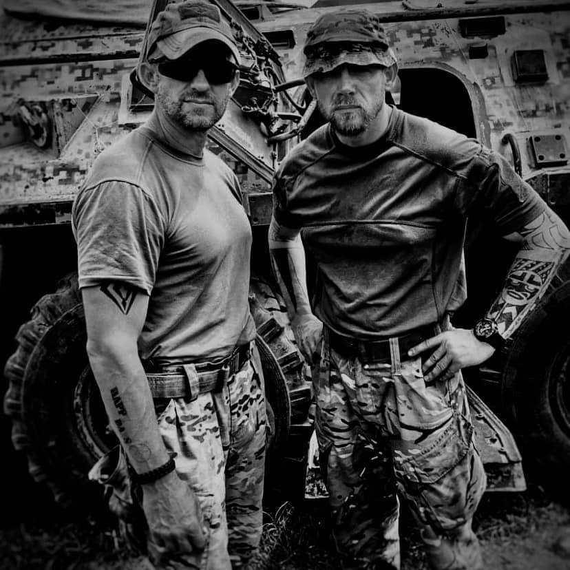 A couple of men posing for the camera

Description automatically generated with medium confidence