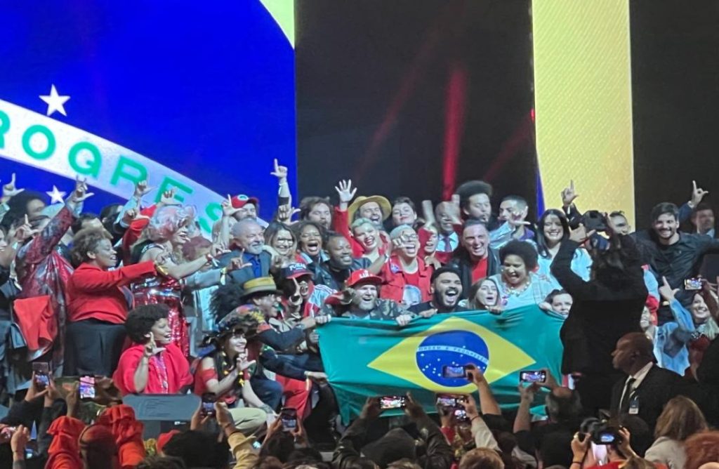 A group of people holding flags Description automatically generated with medium confidence