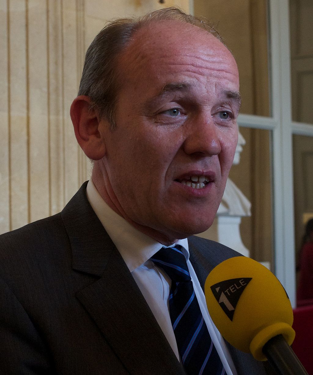 A person in a suit speaking into a microphone

Description automatically generated with medium confidence