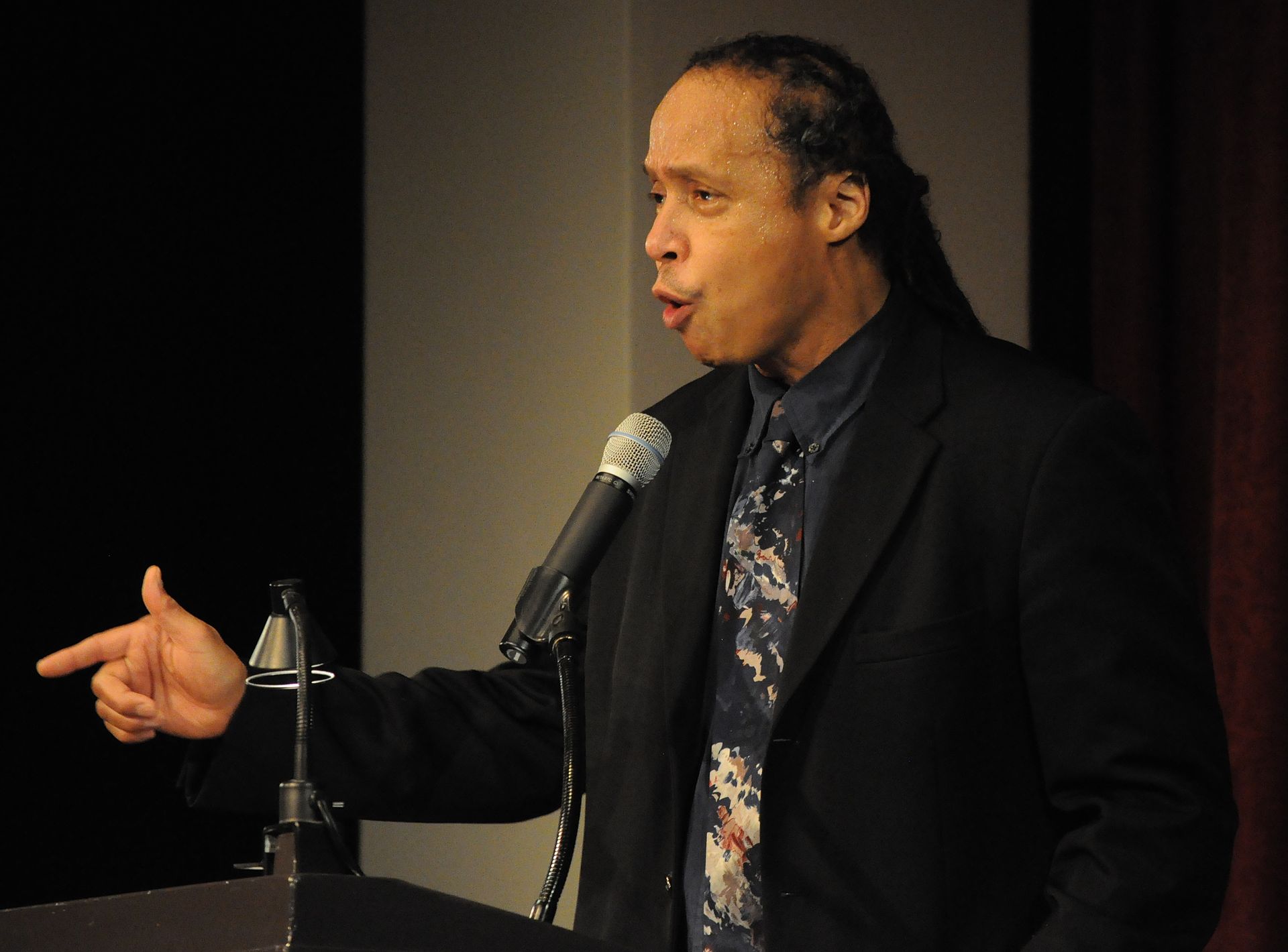 A person speaking into a microphone

Description automatically generated