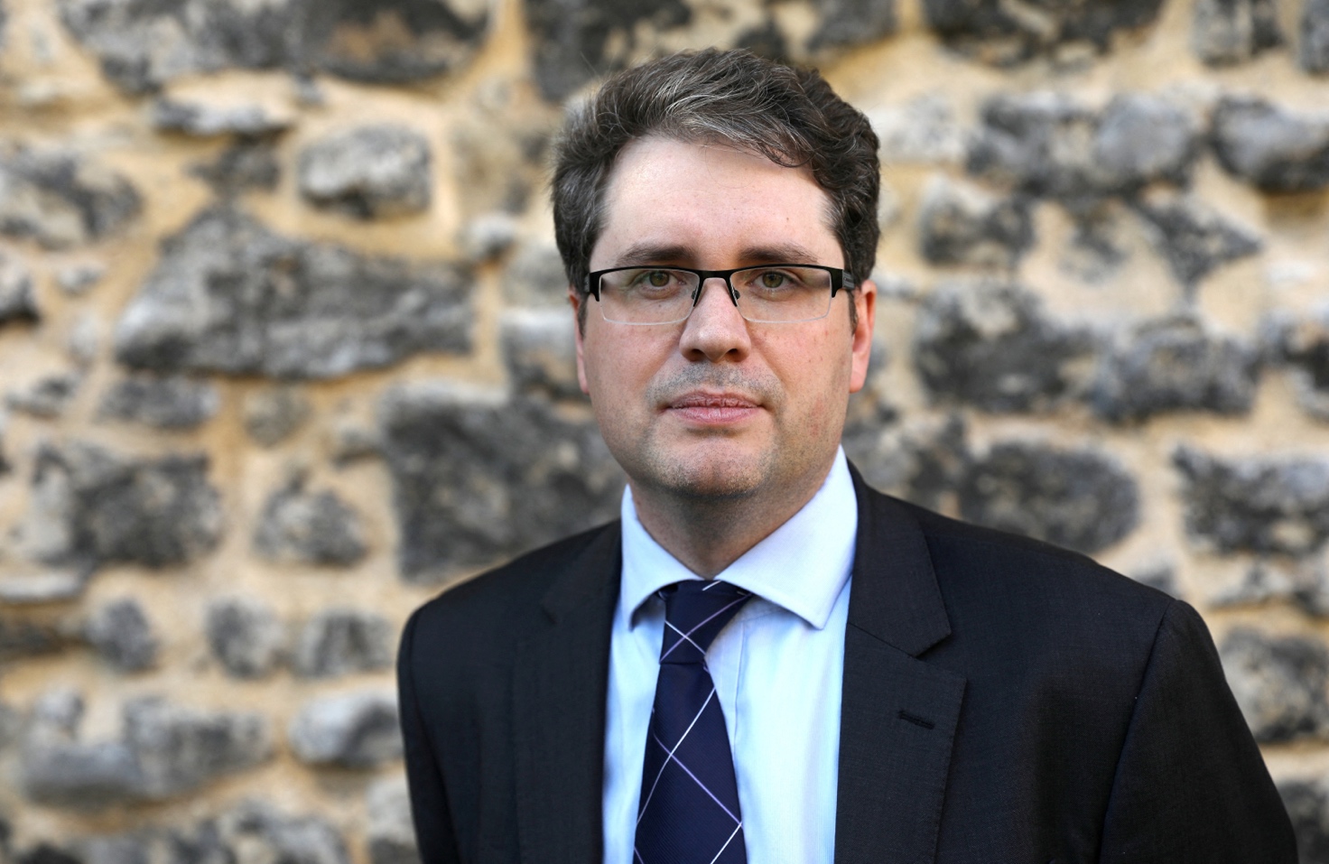 Bellingcat founder Eliot Higgins poses for a portrait after giving a press conference opposite the Houses of Parliament in London