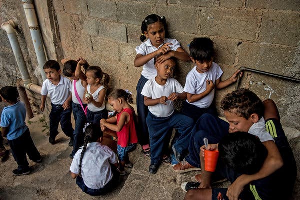 Children waited to eat lunch outside a soup kitchen in a slum near Caracas in February.